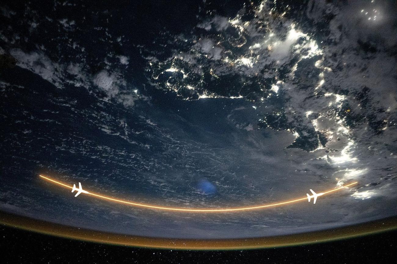Earth's night limb from orbit, with a glowing long-haul route arcing across it