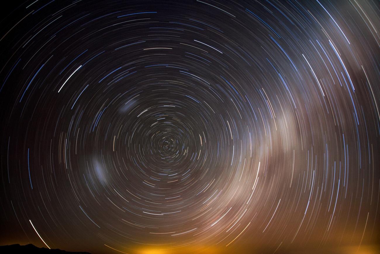 A long exposure of the night sky, stars drawn into concentric circular trails around the celestial pole